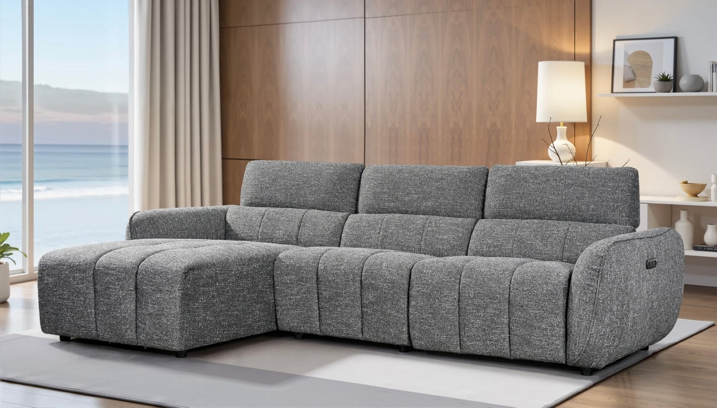 Gray sectional sofa in a modern living room with wooden walls and a lamp.